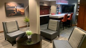 A modern lounge area with comfortable seating, a coffee station, and a TV screen. - Holiday Inn & Suites Duluth Downtown by IHG (Duluth)