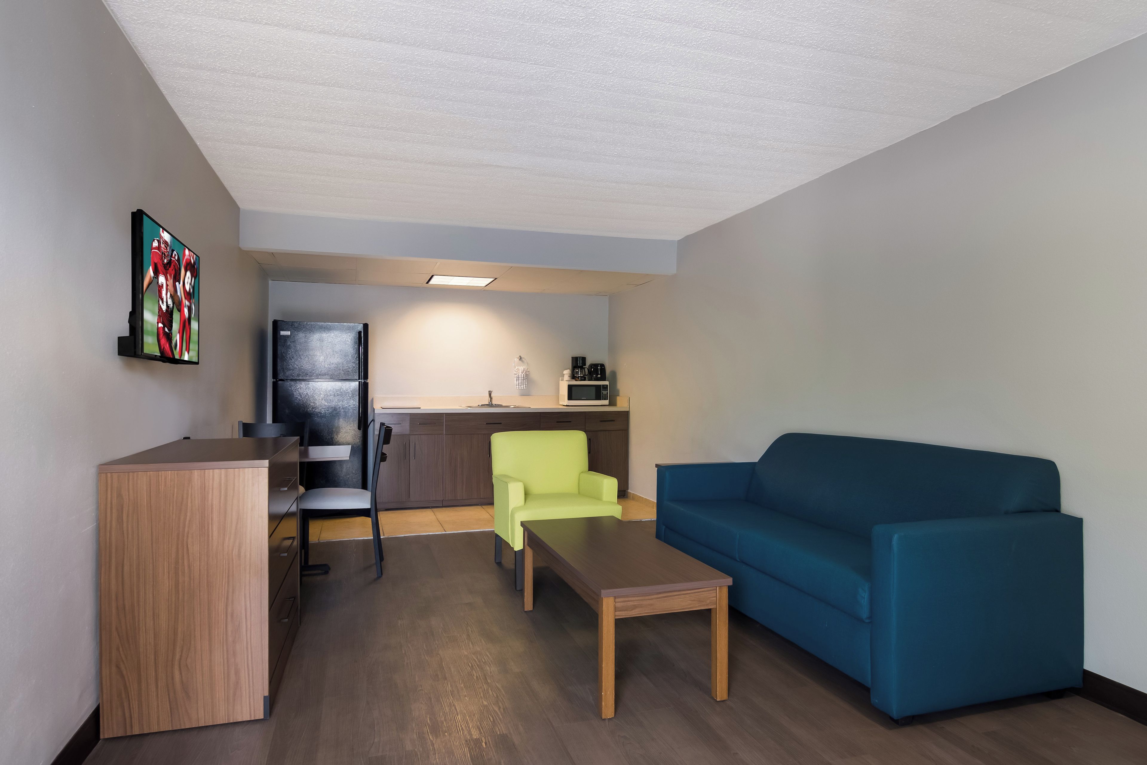 Un espacio habitable compacto con kitchenette, comedor y zona de estar.