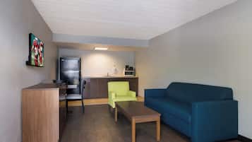 Un espacio habitable compacto con kitchenette, comedor y zona de estar.