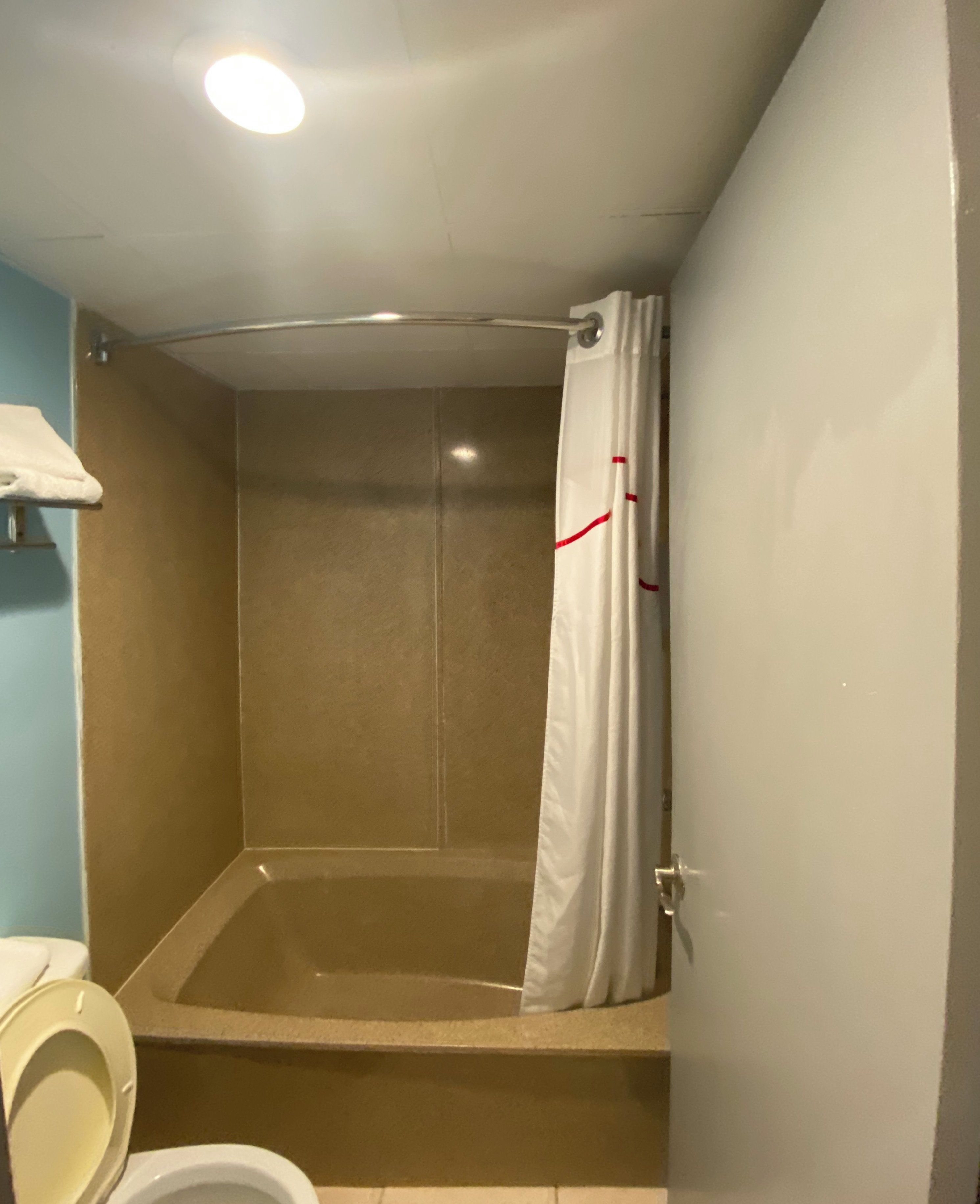 Une salle de bain avec une baignoire, des toilettes et un rideau de douche.