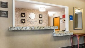 A hotel reception area with a marble counter, a sign reading "Comfort Inn," and a mirror on the wall. - Comfort Inn Ottawa Starved Rock Area (Ottawa)