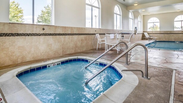 A swimming pool with steps and lounge chairs, large arched windows, and a tiled floor. - Comfort Inn Ottawa Starved Rock Area (Ottawa)