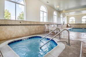 A swimming pool with steps and lounge chairs, large arched windows, and a tiled floor. - Comfort Inn Ottawa Starved Rock Area (Ottawa)