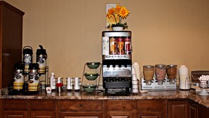 Una encimera de cocina con una cafetera, hervidores de agua y varios recipientes.