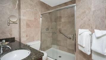 A modern bathroom with a glass-enclosed shower, a sink, and a toilet.