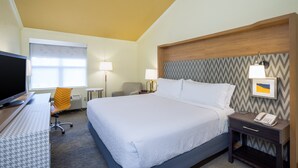 A hotel room with a large bed, a desk with a computer, a chair, a lamp, and a nightstand with a phone. - Holiday Inn Hyannis by IHG (Hyannis)