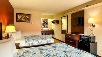A hotel room with two beds, a bathroom with a sink and mirror, a TV, and a microwave.