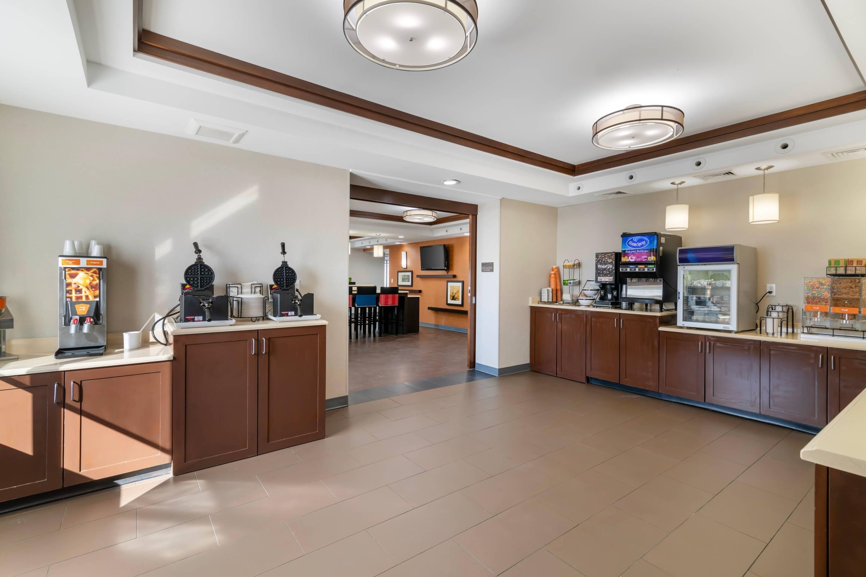 Un hall d’hôtel avec un coin café, un téléviseur et un espace salon.