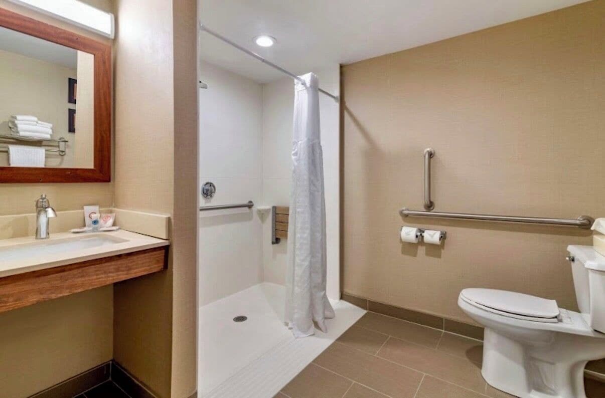 A bathroom with a shower, toilet, and sink.