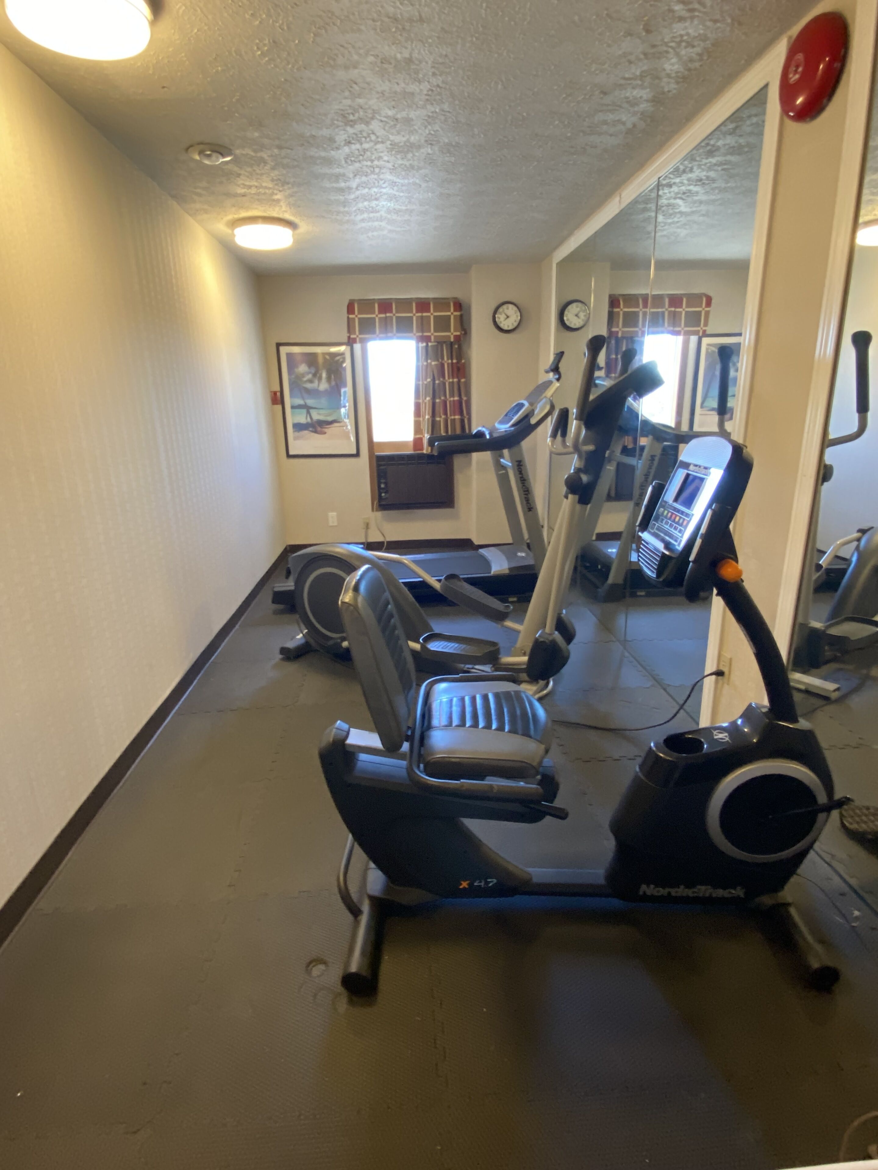 Une salle de sport équipée de vélos d’appartement, d’un appareil elliptique et d’un tapis de course.