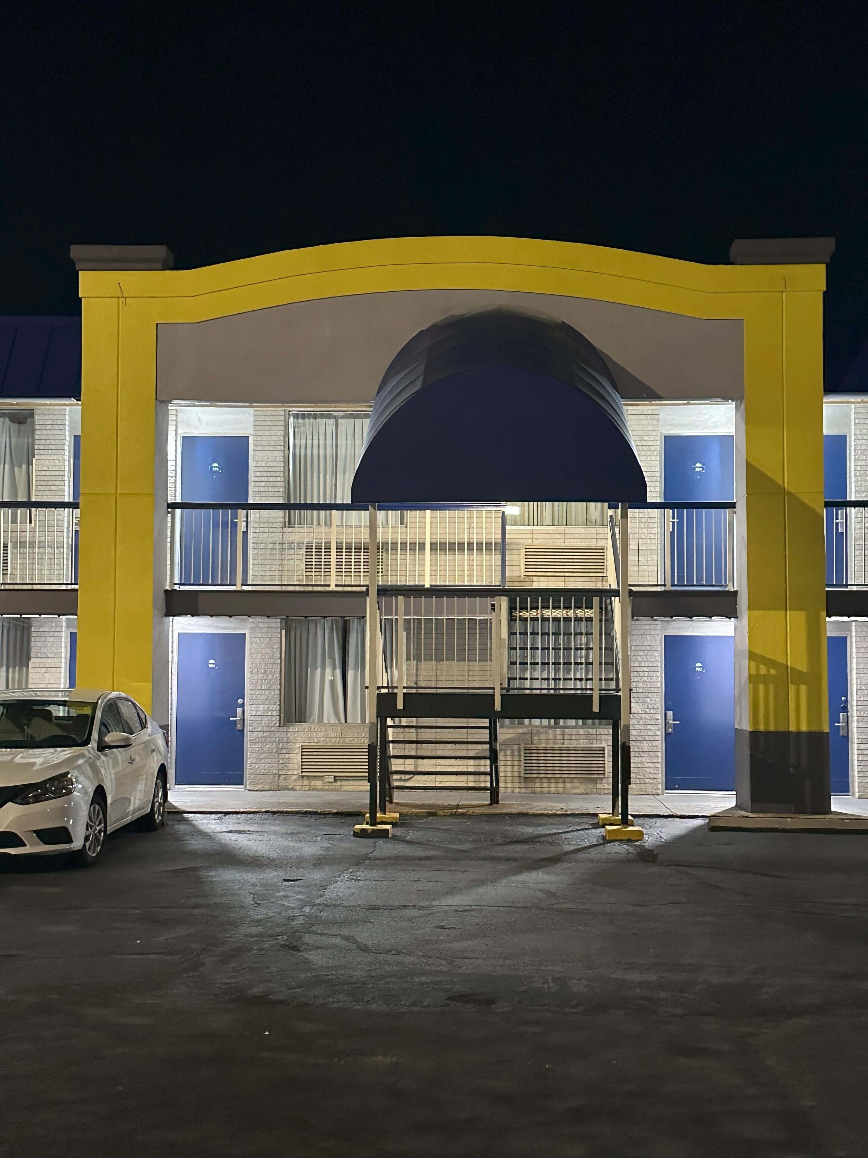 Un parking à étages doté d’une arche jaune et de portes bleues.