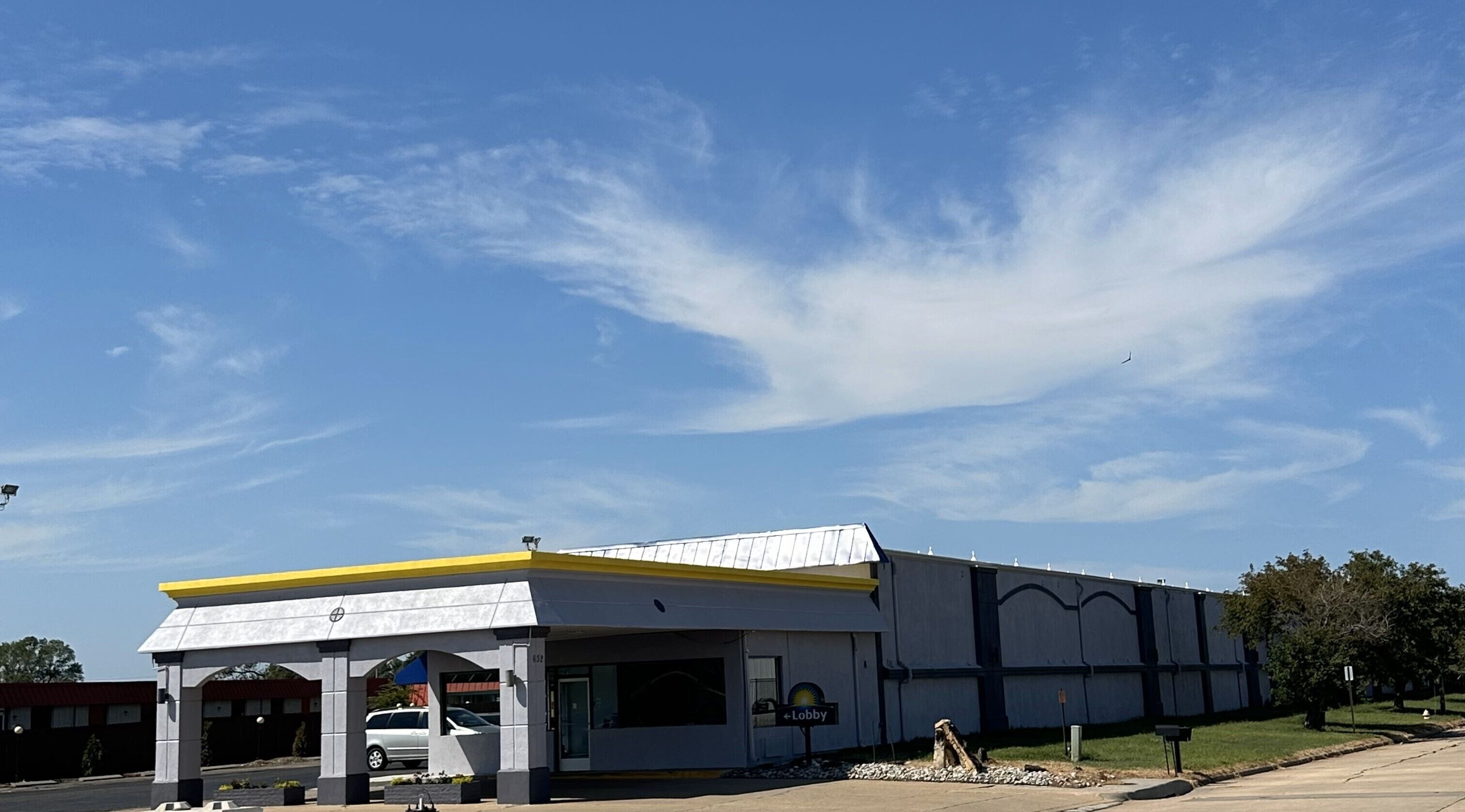 A modern building with a yellow roof and a sign indicating a lobby.