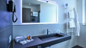 Un bagno moderno con doppio lavabo, uno specchio grande, un asciugacapelli e un porta asciugamani.