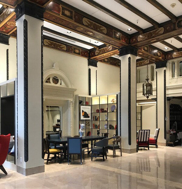 A spacious lobby with high ceilings, ornate ceiling details, and a central seating area with chairs and a table. - Hotel Spero, Vignette Collection by IHG (San Francisco)