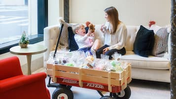 Relax in this inviting space with a sofa, a vintage wagon, and a red chair.