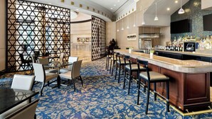 A hotel lobby with a bar area, seating arrangements, and a patterned carpet. - Renaissance Dallas North Hotel (Farmers Branch)