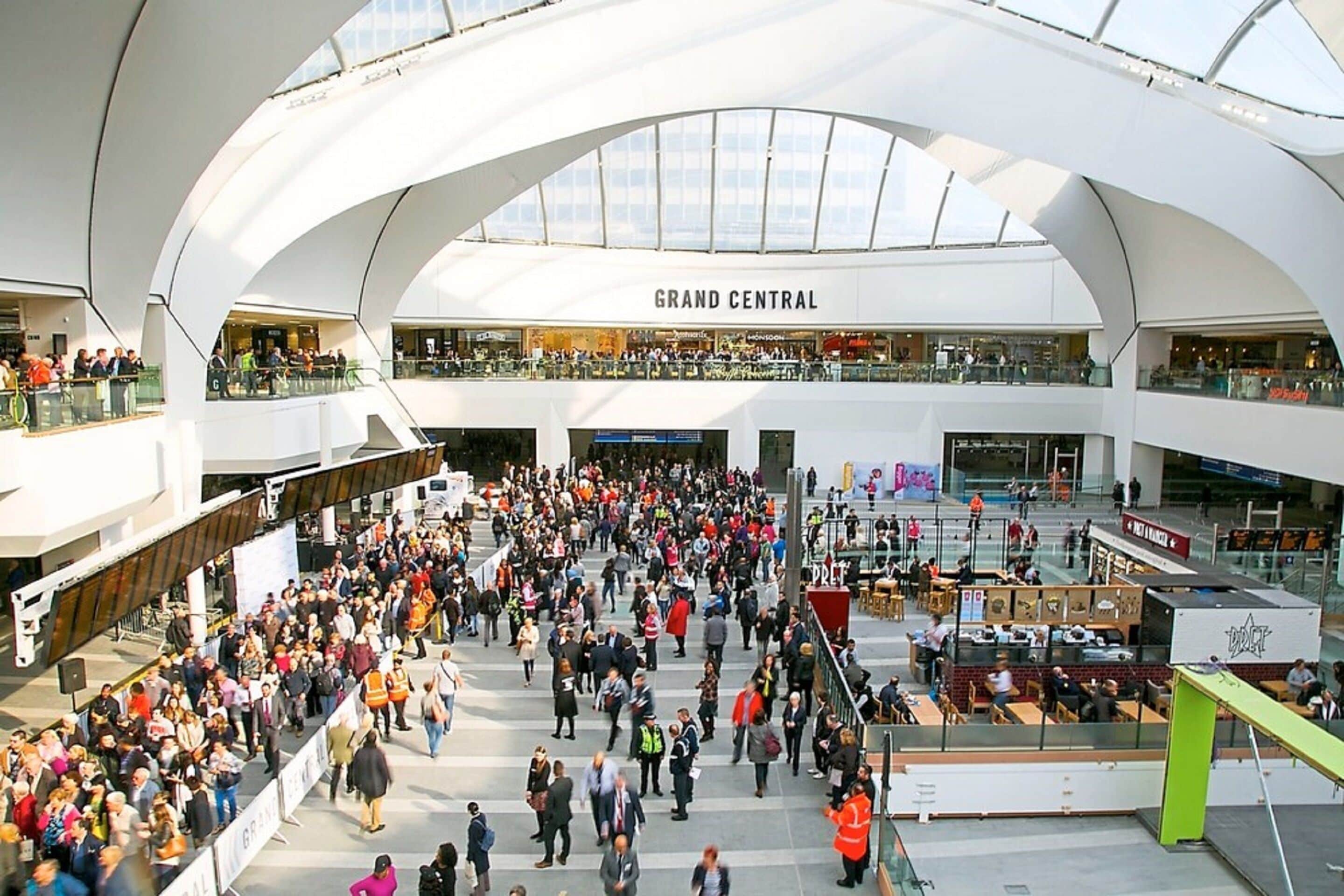 A spacious indoor area with multiple levels, featuring a central open space with a high ceiling and natural light.