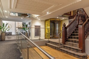 A grand staircase with a wooden finish and a glass railing, leading to an upper floor. - Britannia Hotel Birmingham New Street Station (Birmingham)