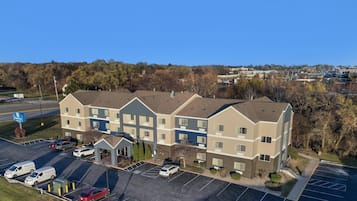 A multi-story hotel with a parking lot and a road in the foreground.