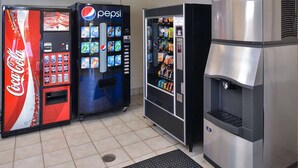 Zona de máquinas expendedoras con Coca-Cola, Pepsi y un dispensador de agua.