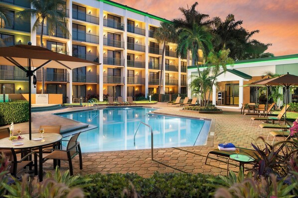 Relax by the pool surrounded by comfortable lounge chairs and shaded areas.