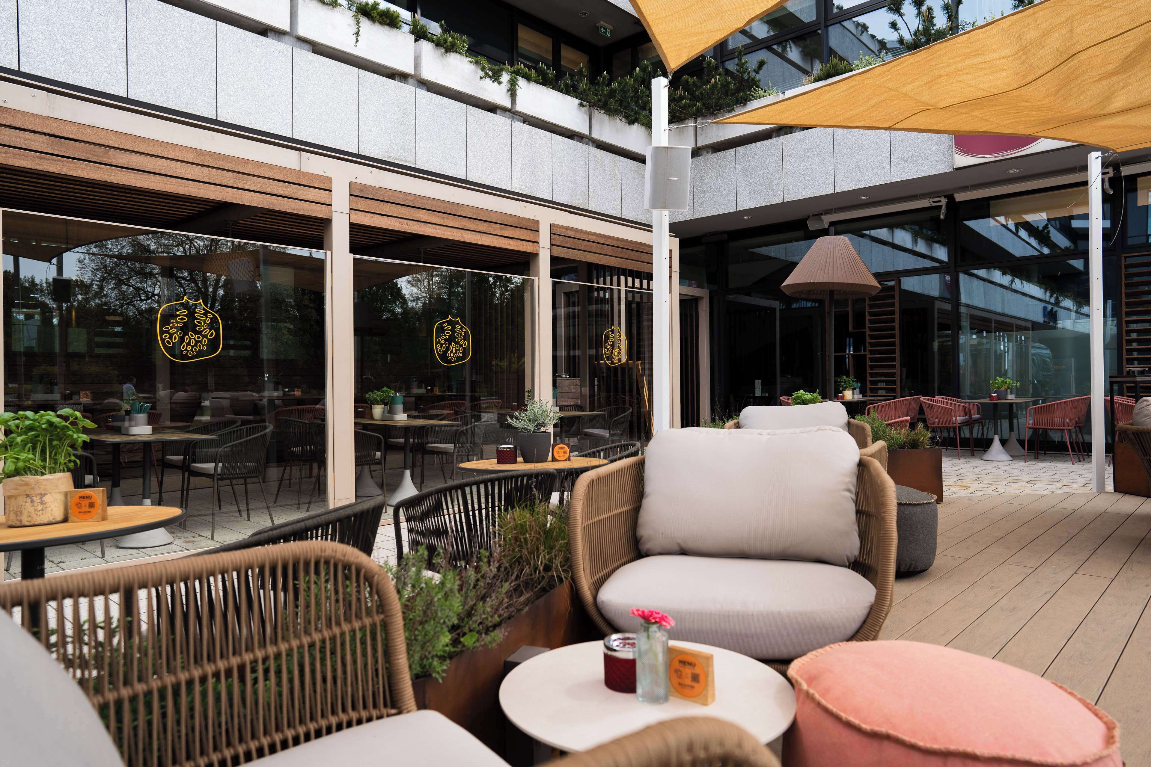 An outdoor seating area with wicker furniture, a wooden table, and a yellow canopy.