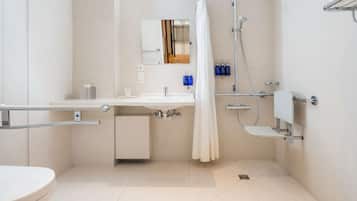 Een moderne badkamer met een witte wastafel, spiegel en douche.