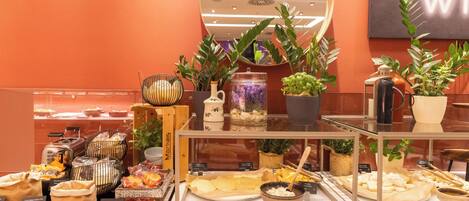 A buffet setup with various food items and a mirror reflecting the room.