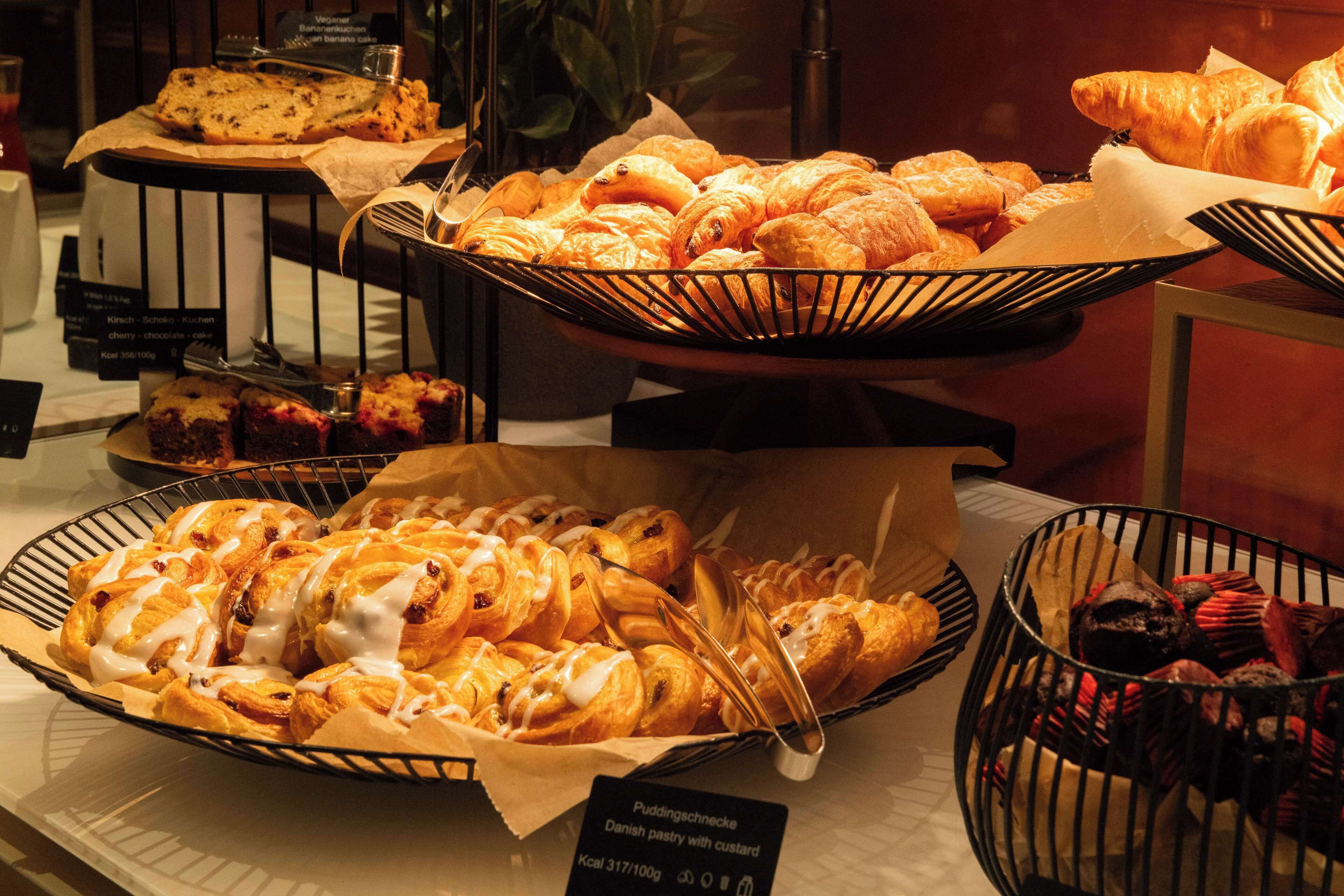 A display of various baked goods including pastries and muffins in baskets.