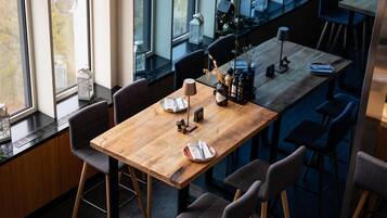 A modern dining area with a wooden table, chairs, and hanging glass orbs.