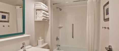 A modern bathroom with a sink, toilet, and bathtub.