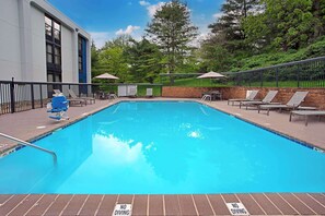 Alberca al aire libre y camastros