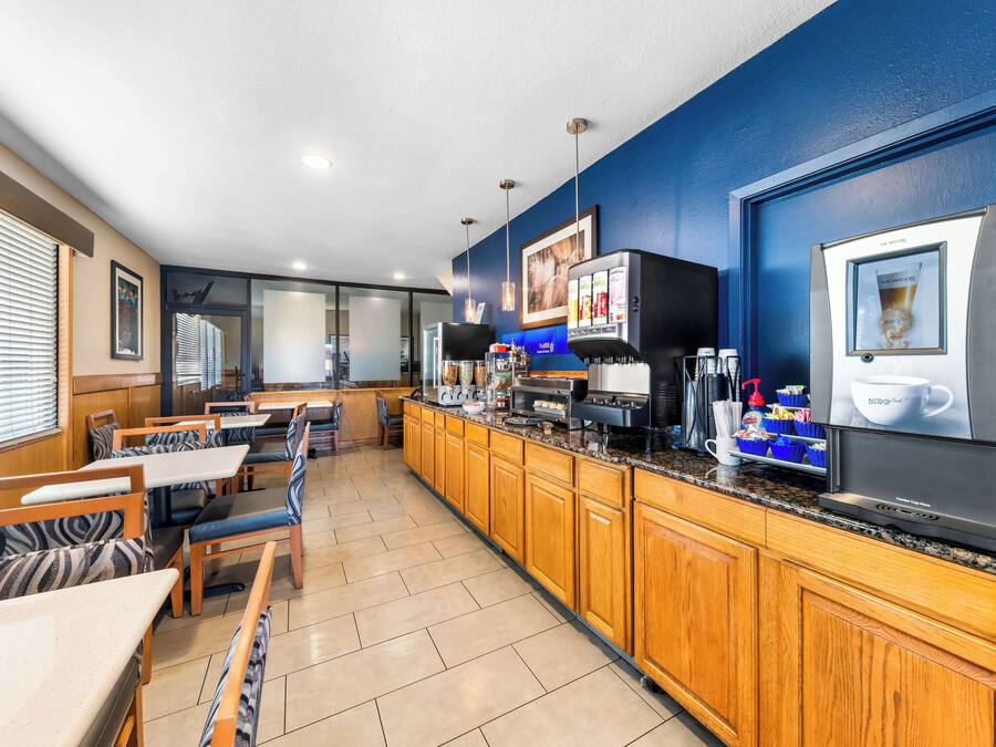 Una cocina moderna con armarios de madera, una cafetera y una pantalla grande que muestra un anuncio de café.