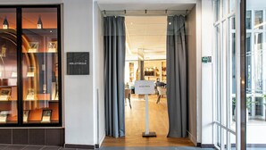 Entrada de hotel con puerta de vidrio, un letrero que dice "BIBLIOTHÈQUE" y un letrero que indica "ACCES PRIVE".
