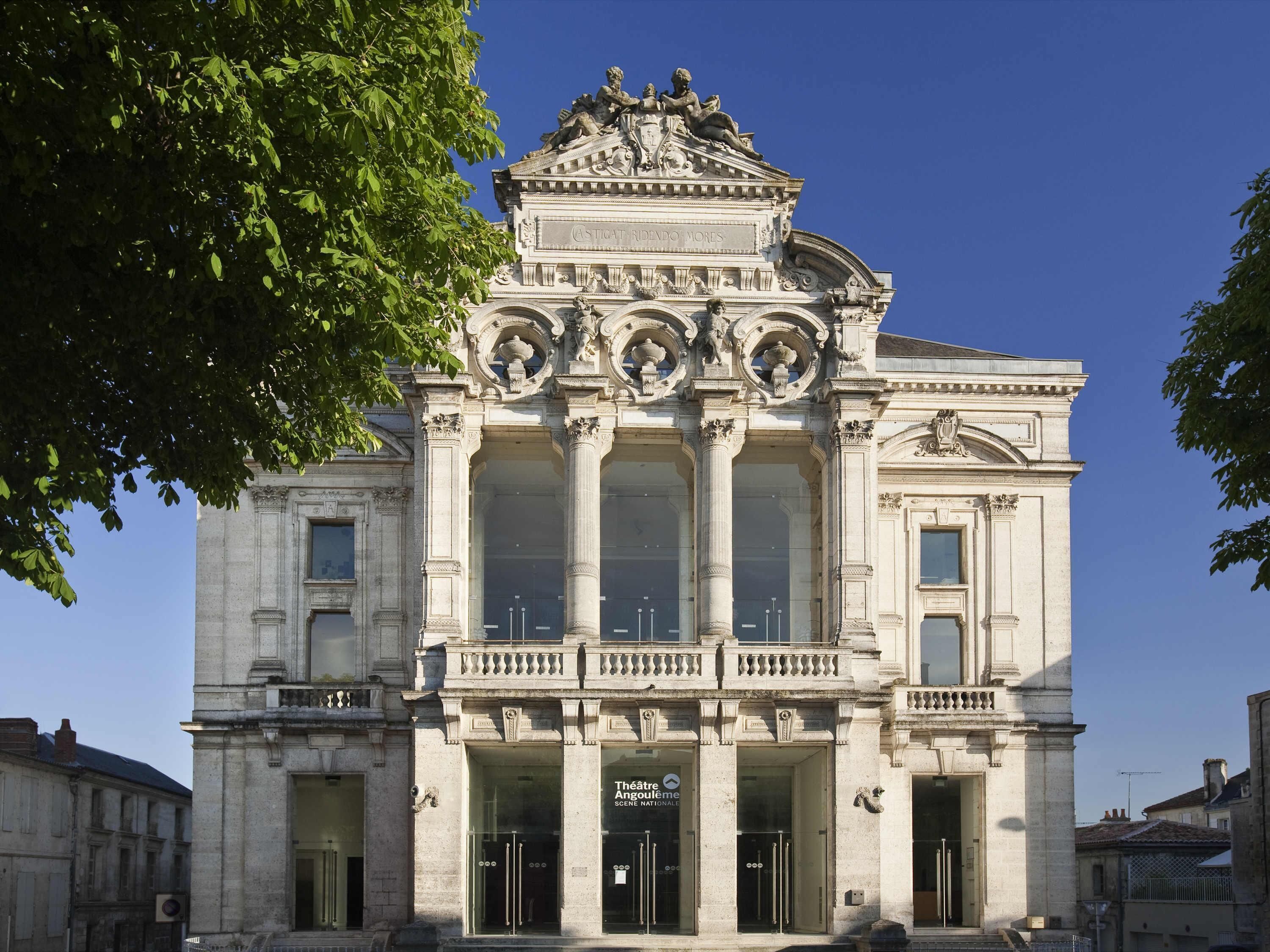 Un edificio clásico con columnas ornamentadas, un balcón y un cartel que dice 'Theatre Angouleme SCENE NATIONALE'.