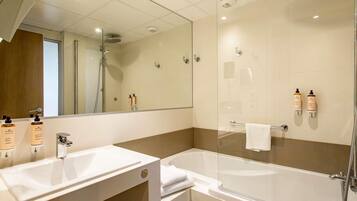 Un baño moderno con ducha de vidrio, un lavabo blanco y una bañera.