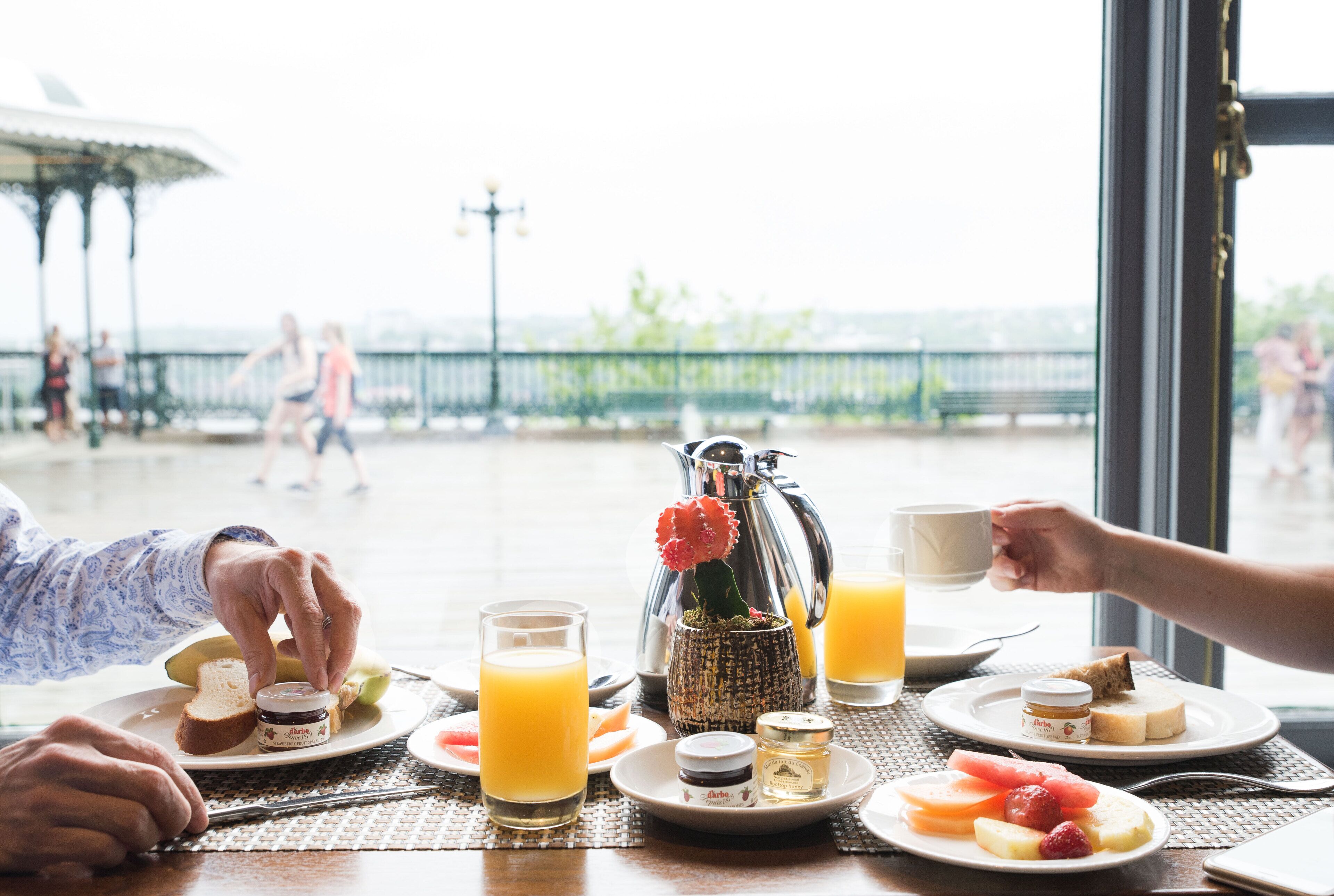 A breakfast setting with a table, plates, glasses, and a pitcher.