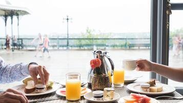 A breakfast setting with a table, plates, glasses, and a pitcher.