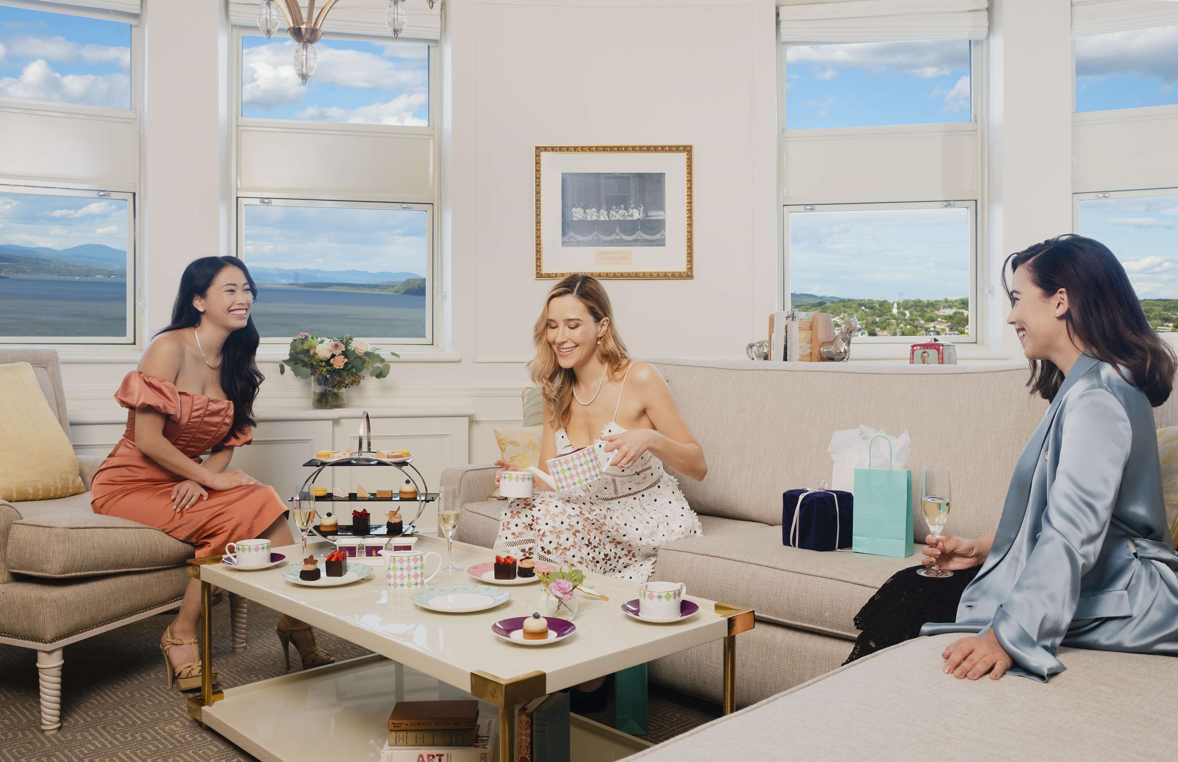 Una habitación con un gran ventanal, una mesa con vajilla para té y un sofá.