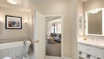 Une salle de bain moderne avec une baignoire, un grand miroir et une douche à l’italienne.