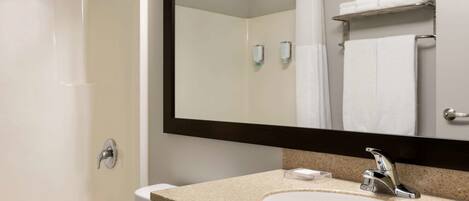 A modern bathroom with a white sink, a large mirror, and a shower.
