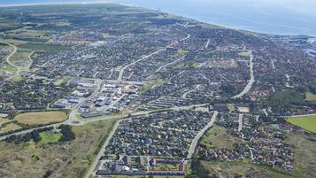 An aerial view of a residential area with houses, roads, and a large industrial complex.