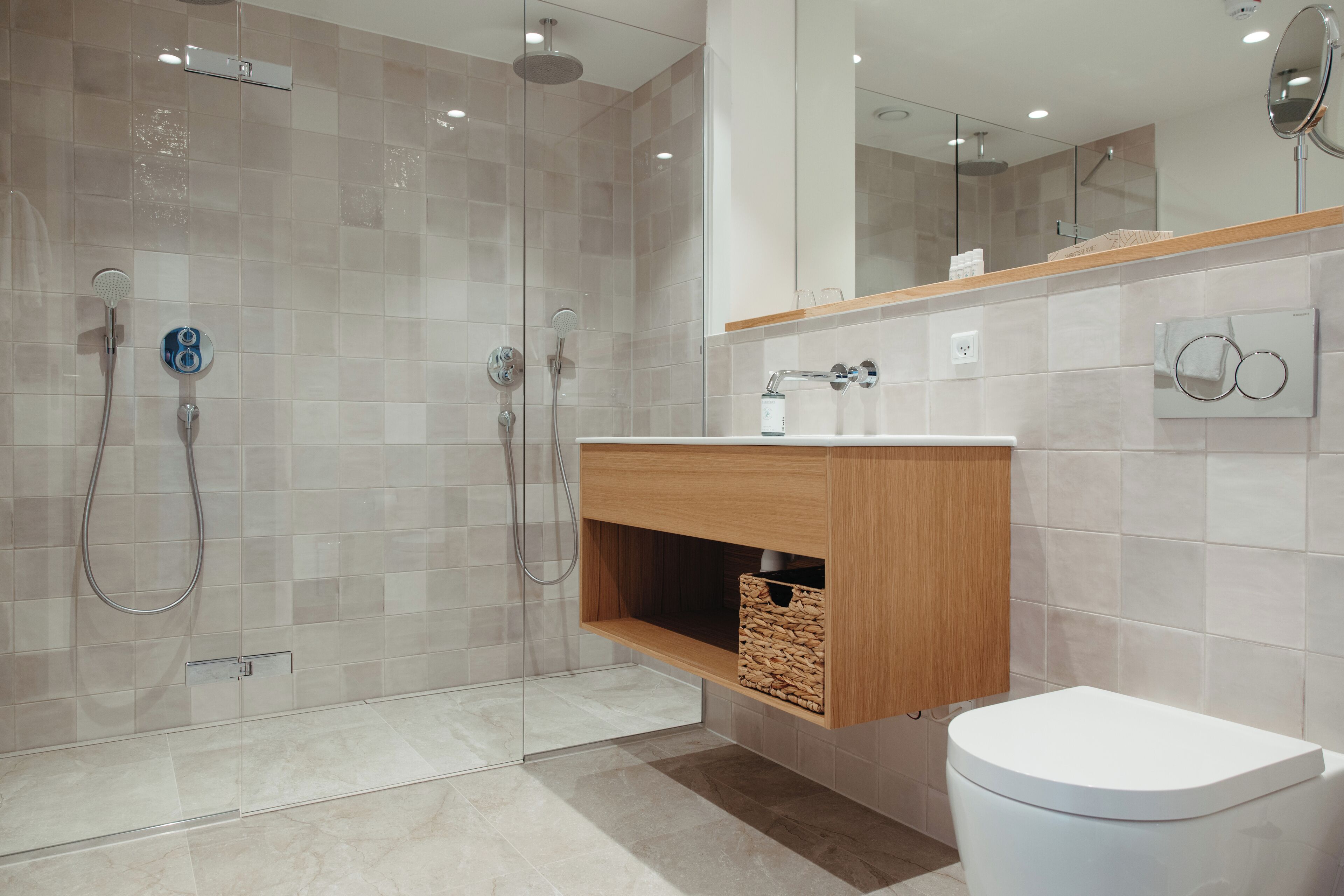 A modern bathroom with a glass-enclosed shower, a wooden vanity, and a toilet.