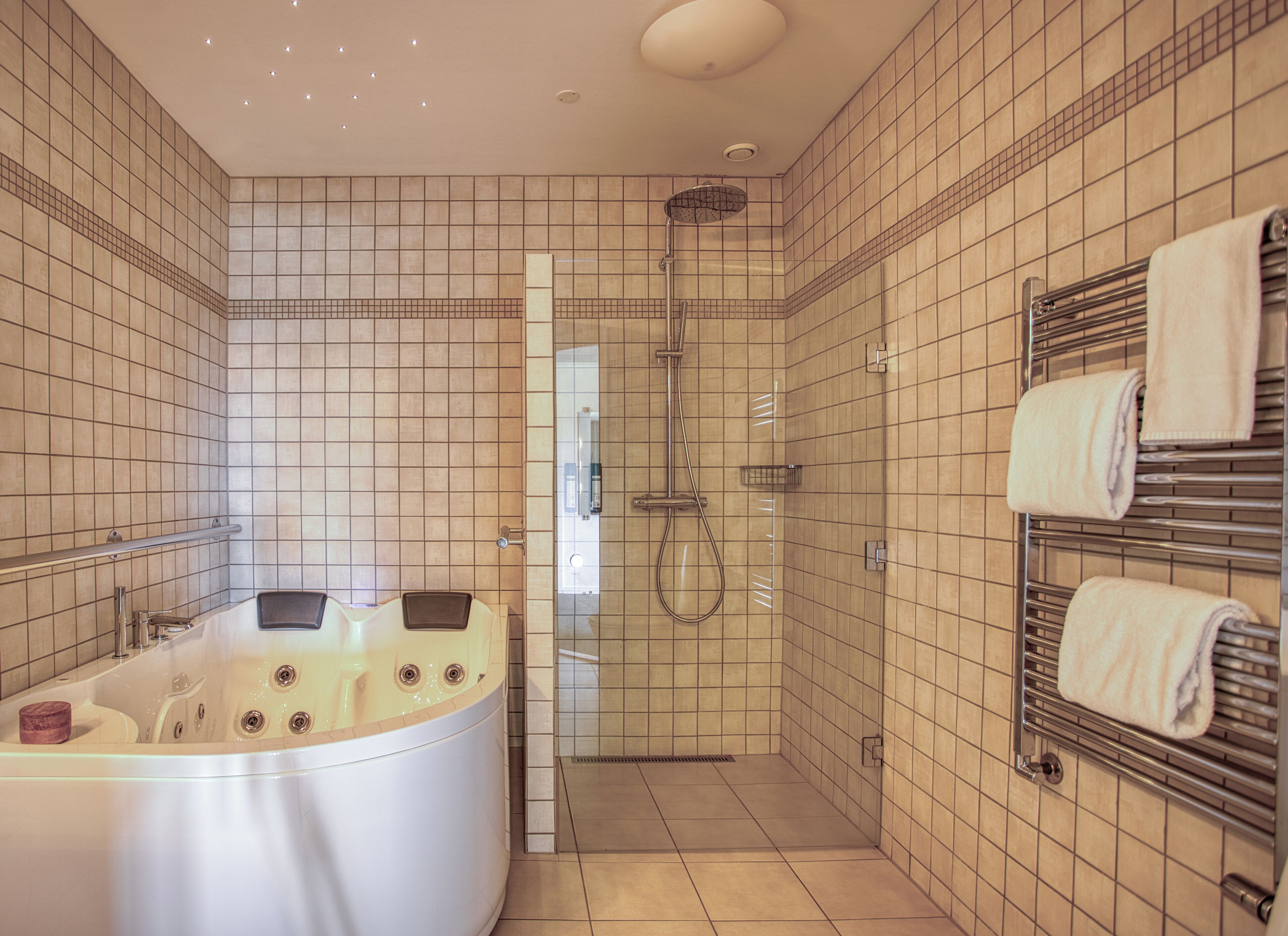 A modern bathroom with a freestanding bathtub, a shower area, and a towel rack.