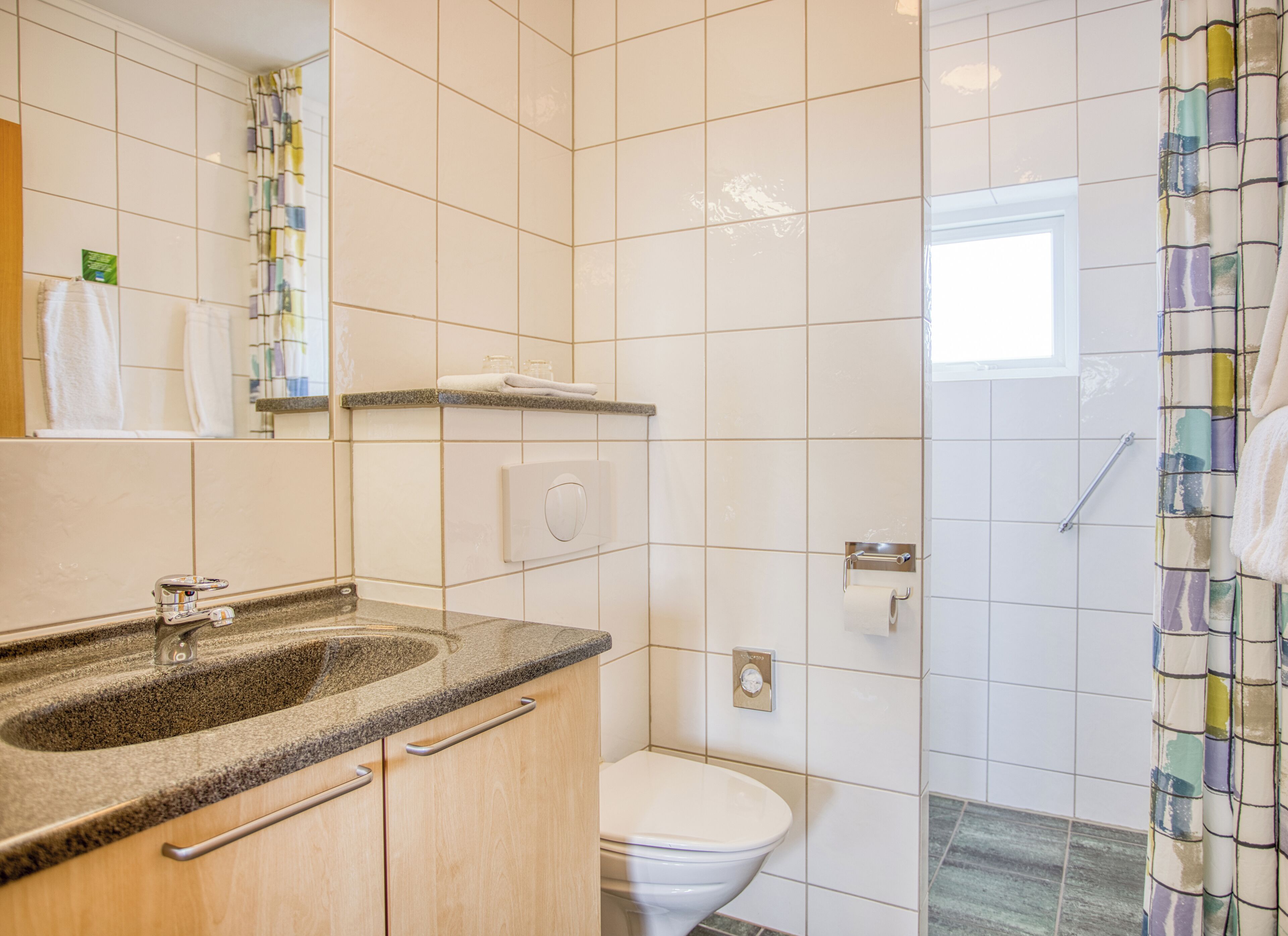 A bathroom with a sink, toilet, and shower.