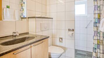 A bathroom with a sink, toilet, and shower.