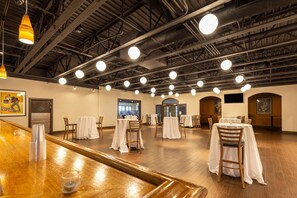 A spacious room with high ceilings, multiple tables with chairs, and a bar area. - Comfort Inn St. Louis - Westport Event Center (Maryland Heights)