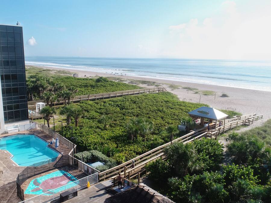 Un hotel con piscina, acceso a la playa y vistas al océano.