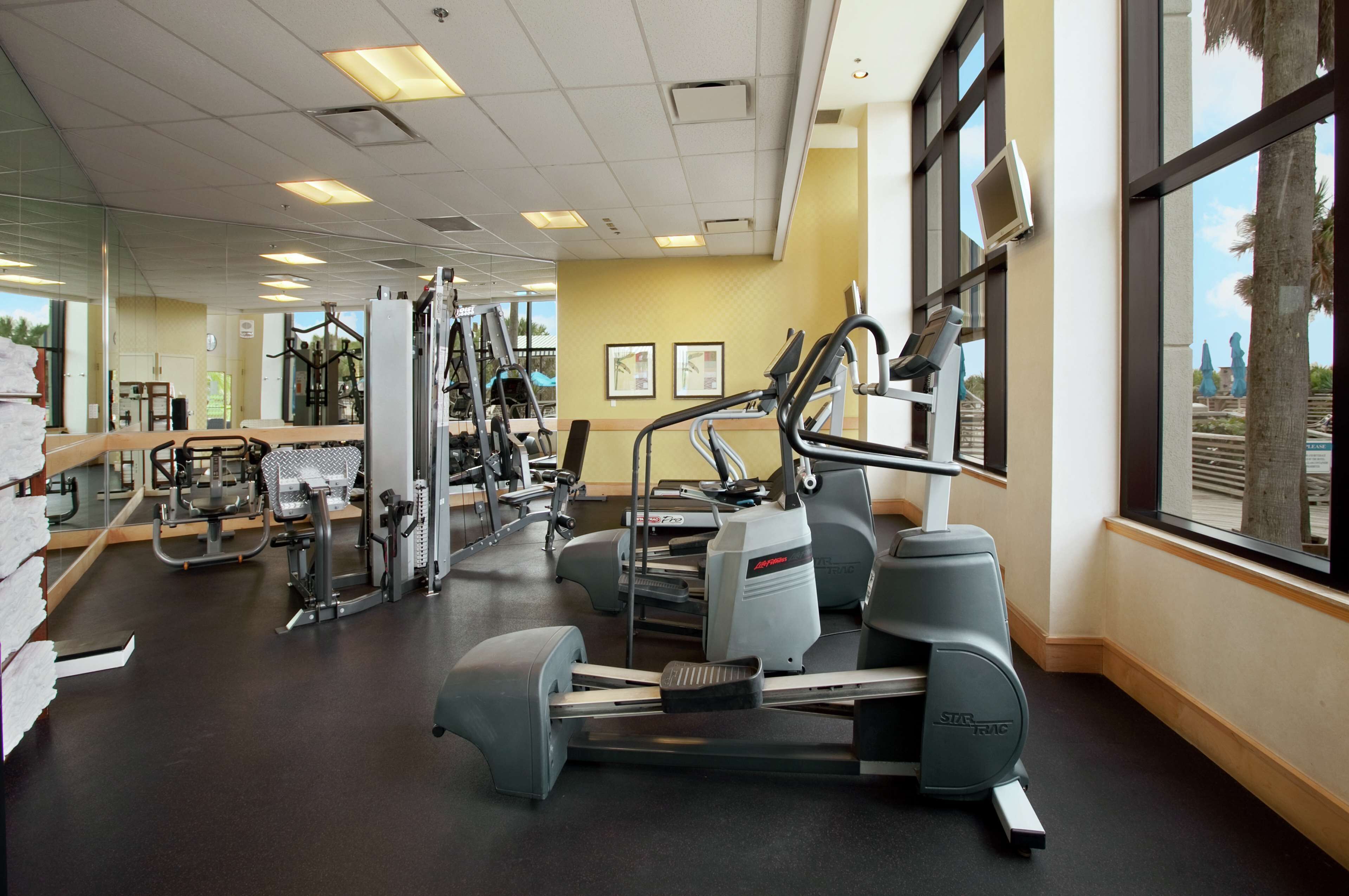 A gym with cardio machines, weight equipment, and mirrors.