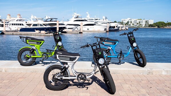 Three bicycles parked by a waterfront with yachts in the background. - Hilton Cocoa Beach Oceanfront (Cocoa Beach)